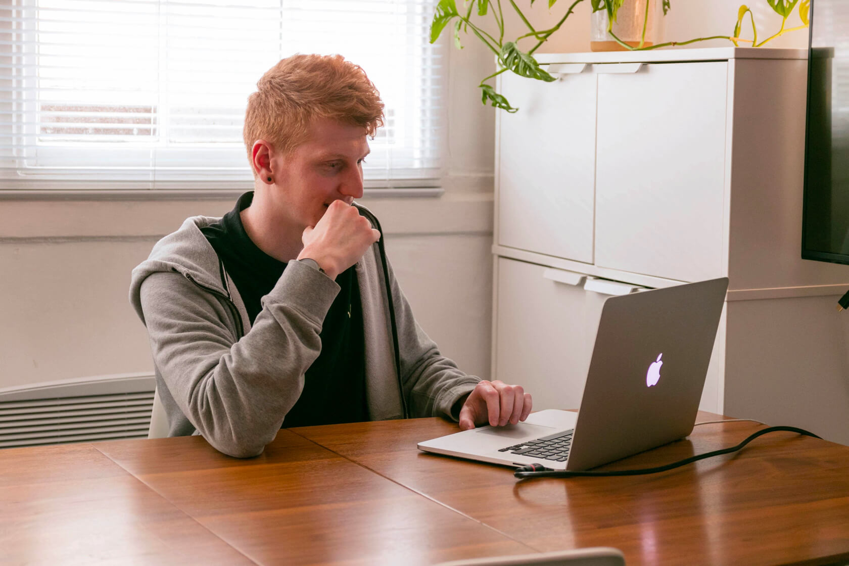 Curt sitting at his desk, deep in thought as he looks for answers on his Macbook Pro.